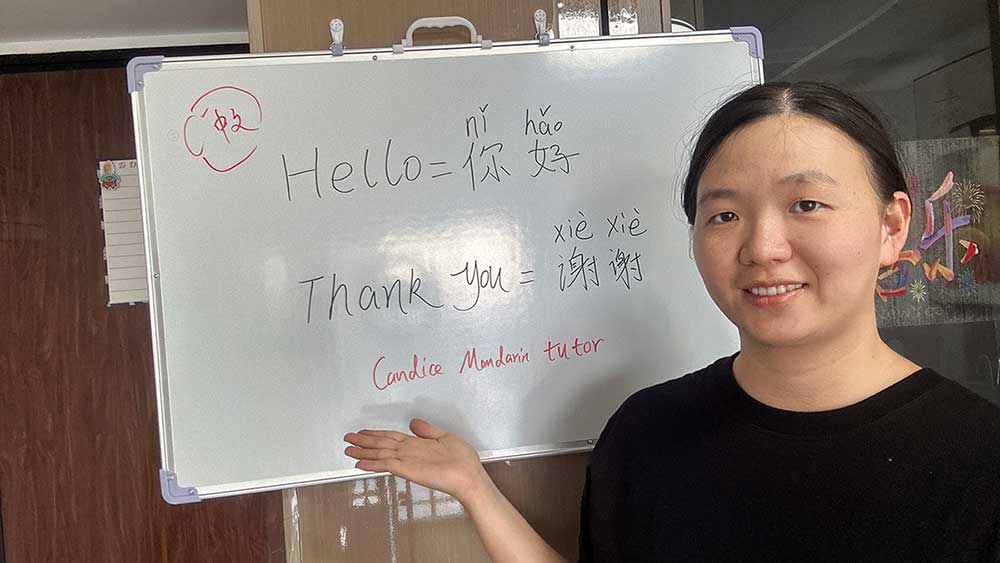 Candice presenting her Mandarin course beside a whiteboard